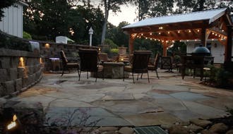 Pergola with lights next to a firepit.