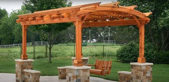 A wooden pergola with a swing.